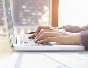 Business woman’s hands typing on laptop keyboard